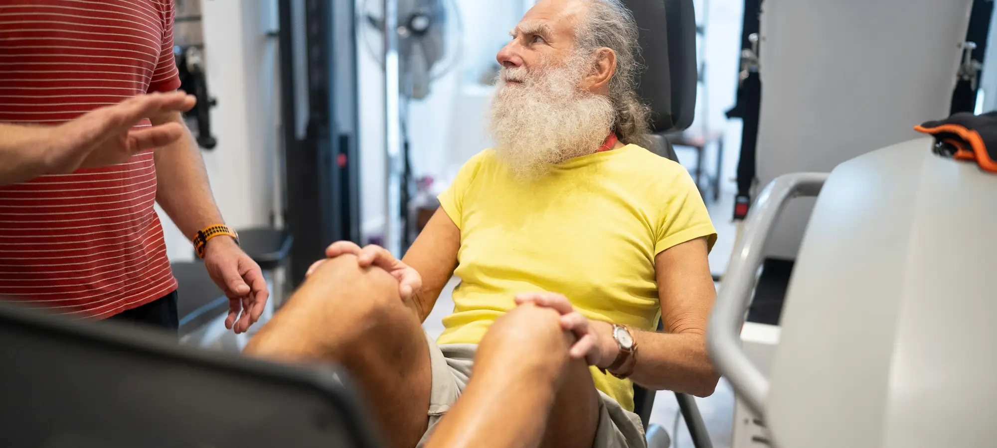 Beyaz sakallı yaşlı bir adam spor salonunda egzersiz yapıyor